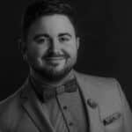 Black and white portrait of Dustin L. in a suit with a bow tie.