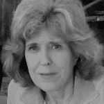 Black and white portrait of a woman with curly hair and a gentle smile.
