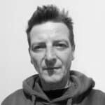 Black and white portrait of Gianpiero B. with short spiked hair and hoodie.