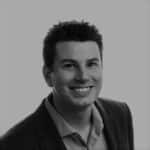 Portrait of a smiling man in a suit, black and white photo.