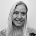 Portrait of a woman with long blonde hair smiling at the camera.