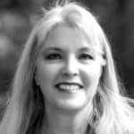 Black and white portrait of a smiling woman with long hair.