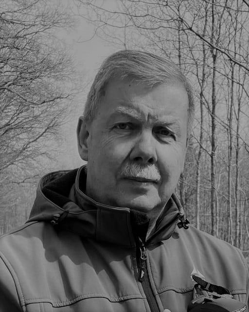 Portrait of Kjeld T. in a jacket outdoors with trees in the background.