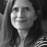 Black and white photo of a smiling woman with long hair.