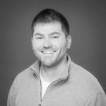 Portrait of Micah Z., a reality capture specialist, smiling in a professional headshot.
