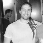 Portrait of Oded M. smiling, with a reflection in the background.