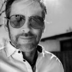 Man with sunglasses outdoors in bright sunlight.
