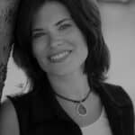 Black and white portrait of Patricia G. smiling outdoors.