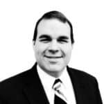 Professional portrait of Ryan H. in a suit and tie.
