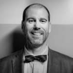 Portrait of Sean H. in formal attire, smiling, black and white photo.