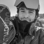 Skier wearing helmet, goggles, and winter gear outdoors.