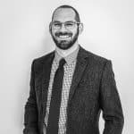 Portrait of Spence F. in professional attire, smiling.