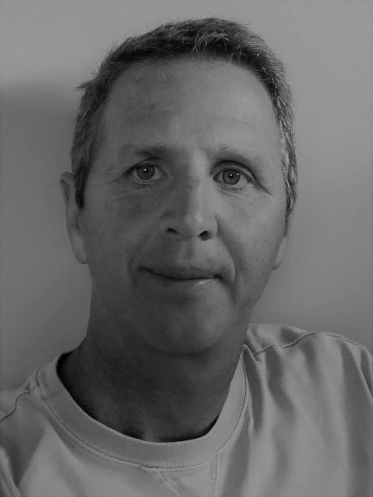 Portrait of a man with short hair in grayscale.