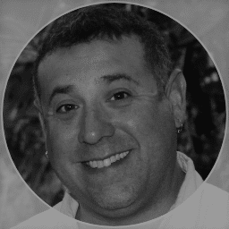 Close-up of a smiling man with short hair, in black and white.