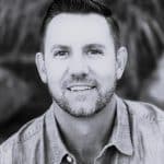 Portrait of William A., a reality capture specialist, smiling outdoors in black and white.