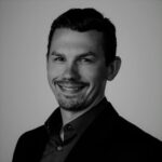 Headshot of Zachery R. in professional attire, smiling.