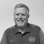 Portrait of Mike V. smiling, wearing a Florida Gators polo shirt.