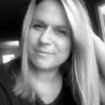 Black and white portrait of a woman with blonde hair and a slight smile.