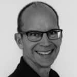Portrait of Eric O.., smiling man with glasses, professional headshot.