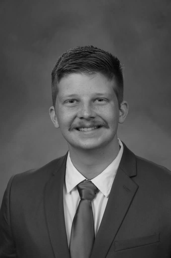 Black and white portrait of Logan H. in a suit and tie.