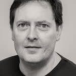Black and white portrait of Tony P. with neutral background.