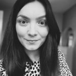 Black and white photo of a woman with dark hair and a patterned top.
