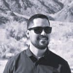 Nick N. wearing sunglasses in a mountainous outdoor setting.