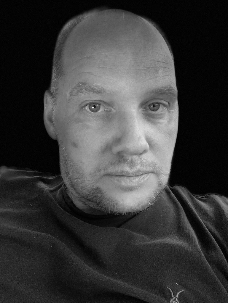 Black and white portrait of a man with short hair and beard.