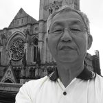 Man taking selfie outside historic Gothic cathedral with detailed facade.