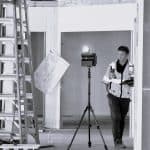 Construction worker with 3D laser scanner on a building site.