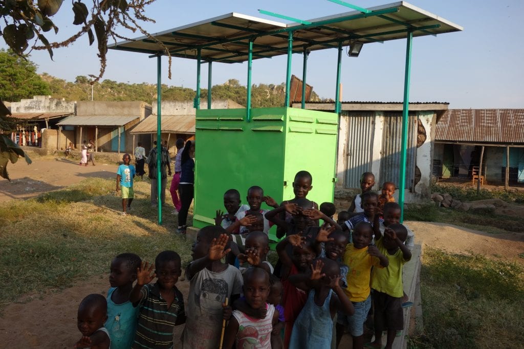 Children waving in the fishing village of Got Kachola. 