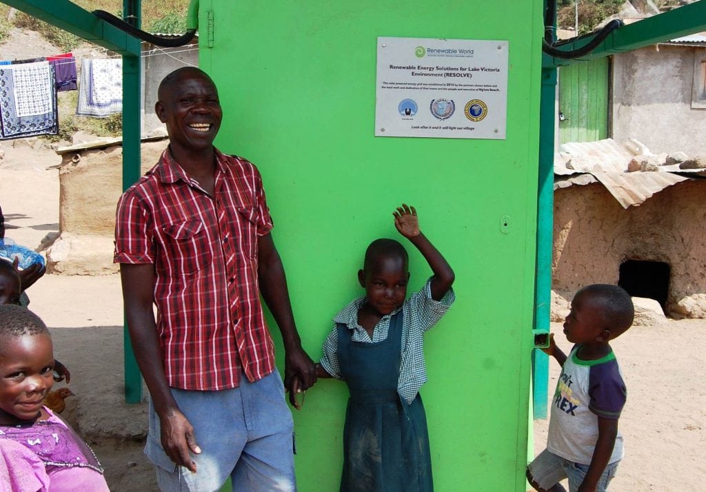 Charles smiling in front of Ng’ore's energy hub. 