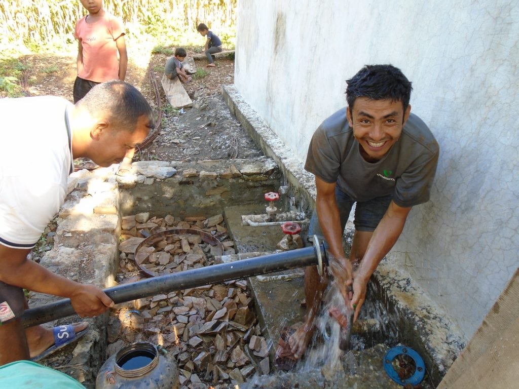 a man washing his hands with water from the newly installed solar water pumping system