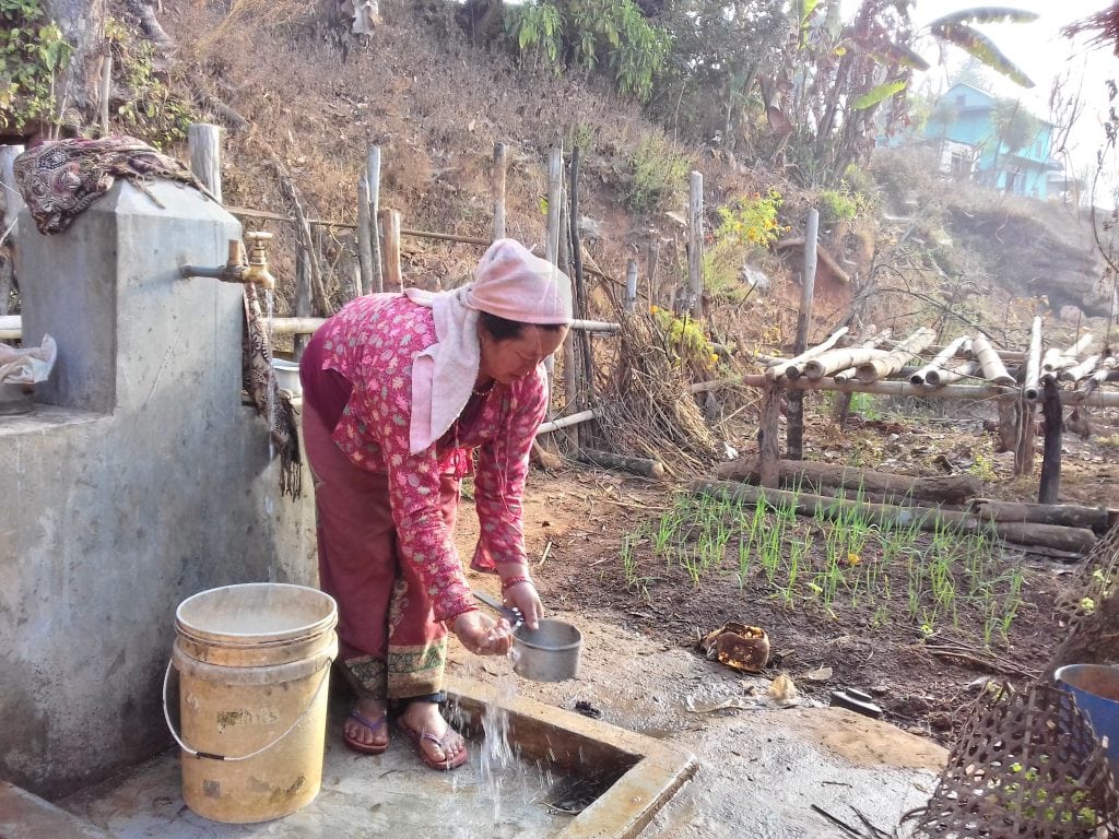 Hum Kumari at the tap stand outside her family home