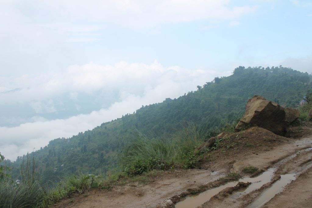 View in Nepal from a muddy road looking across hills. 