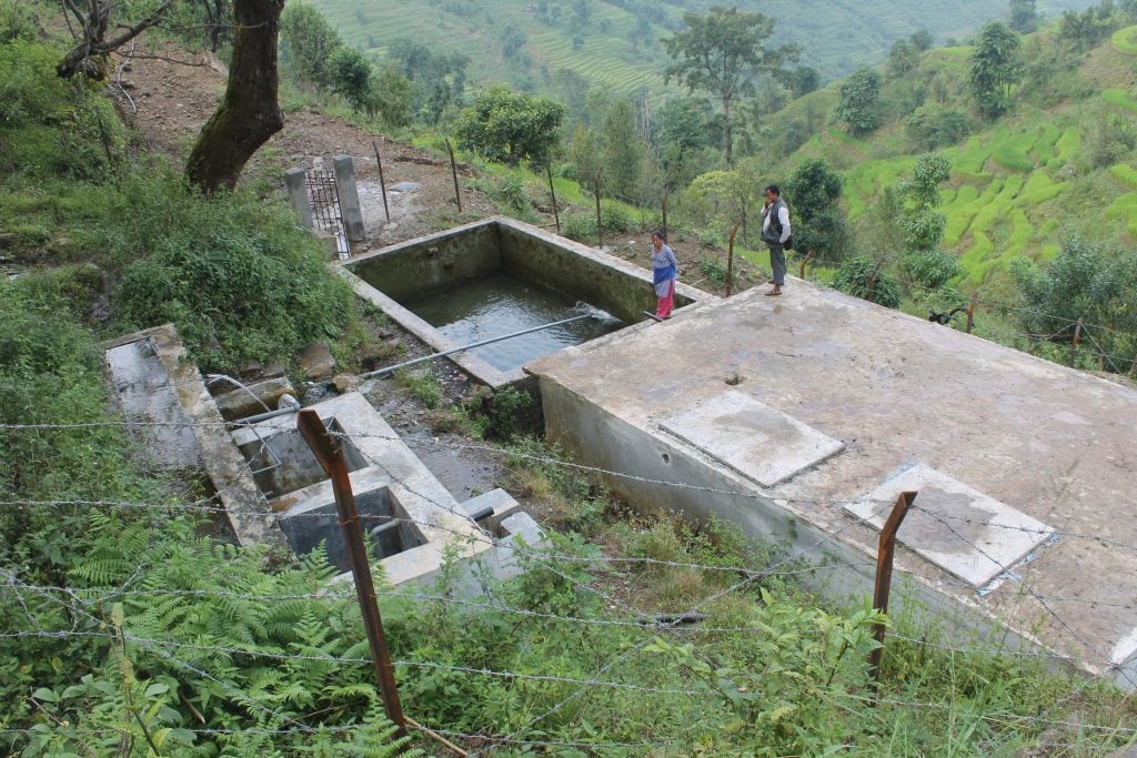 A large rectangular water tank surrounded by fencing