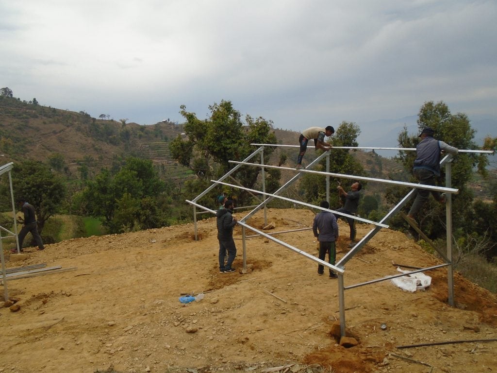 Solar panel frame fully erected with community members observing