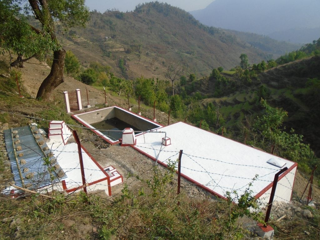 The rectangular water tank, painted white with red trim. 