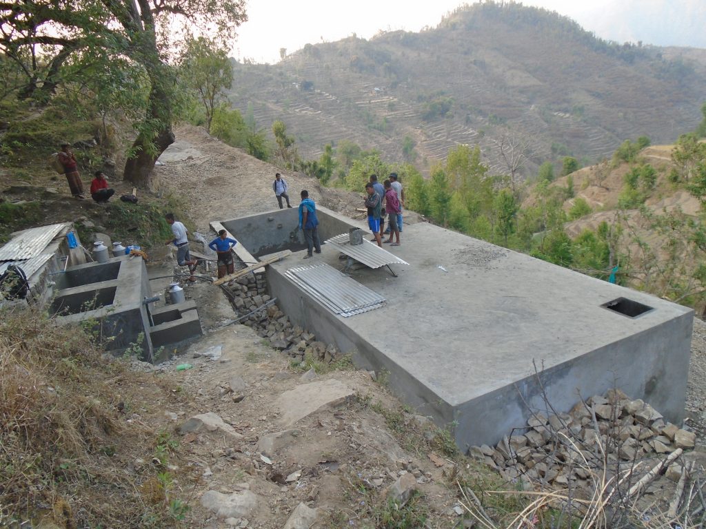 View of a large rectangular water tank on a hillside in Nepal