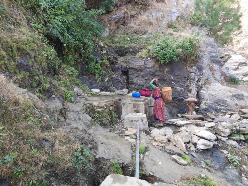 A woman fetching water from the source closest to Layati village.