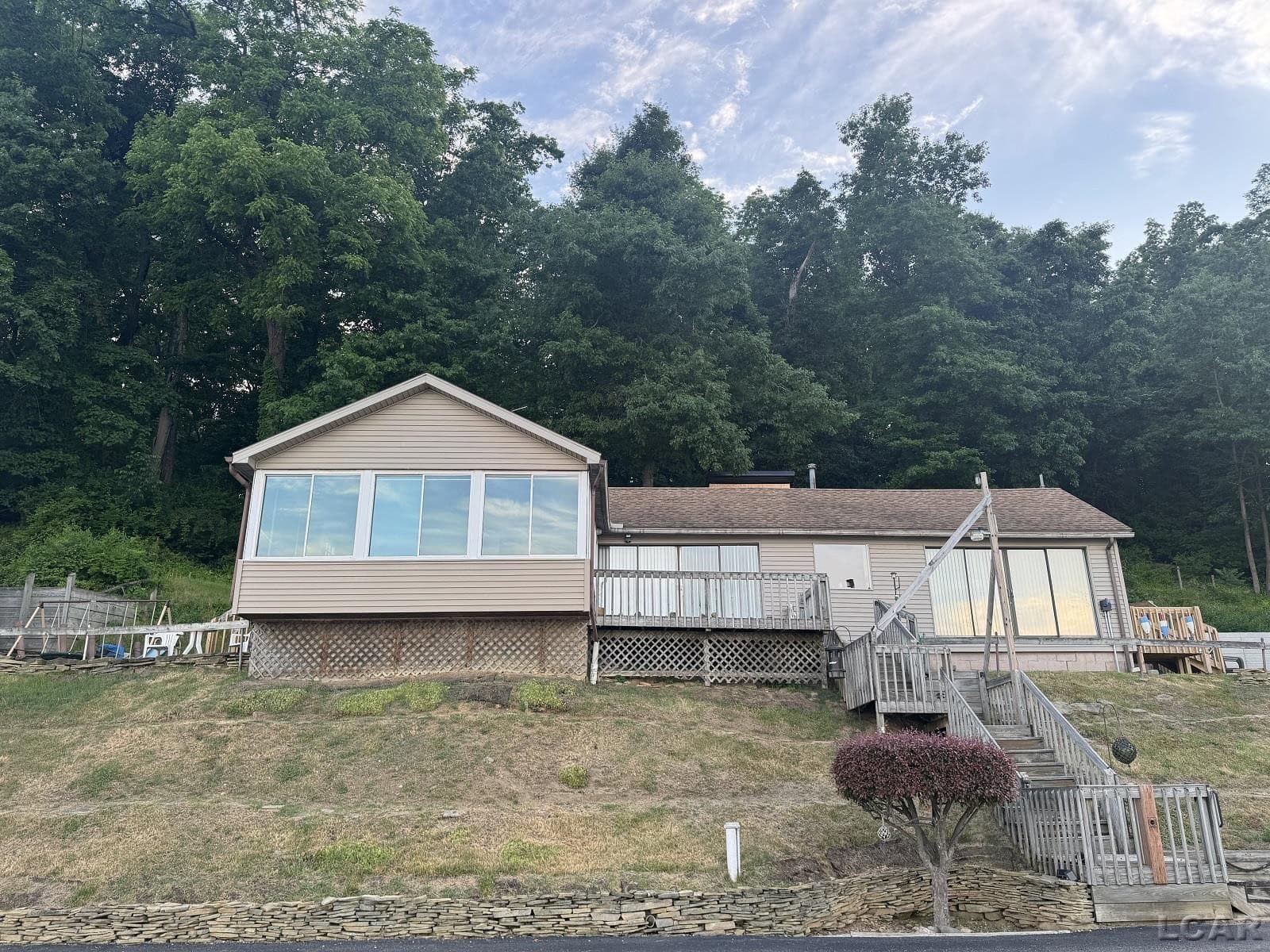 A rare opportunity to own 114 ft. of sandy beach on beautiful all sports lake, Sand Lake.  A spectacular view from this home that is priceless!  A ranch style home with 3 bedrooms, full bath, laundry room, family room & dining area.  Located on a private paved road with sewer and well. Move in ready with appliances and newer flooring throughout the home.  Small workshop for the handy person of the home.  Schedule your showing today!