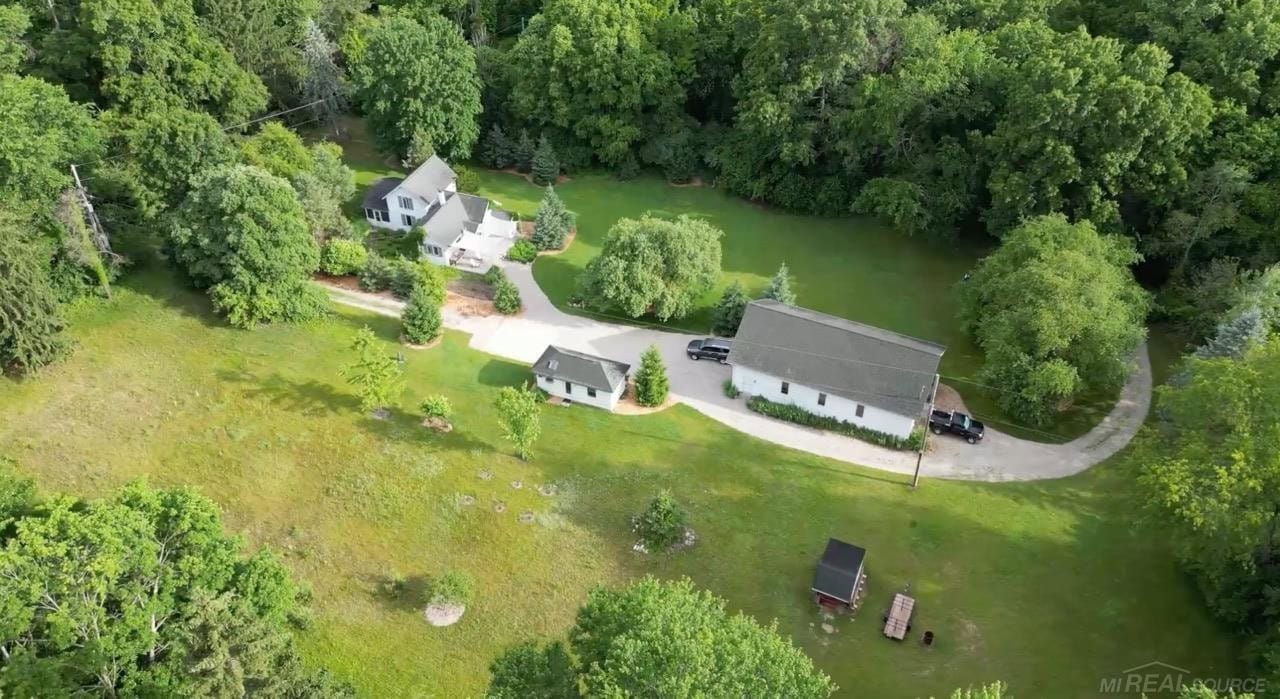 Historic farmstead offers a peaceful retreat minutes from downtown Ada. Set on 3.3 serene acres in Forest Hills Eastern, this property blends timeless character with exceptional versatility. 1,296 sq-ft home with 2 bedrooms, 2 full baths, and main-floor utility. Solid oak flooring and wooden Pella windows for plentiful natural light. Kitchen has custom cabinetry, granite counters, and stainless KitchenAid appliances; built-in gas grill and herb garden just outside. Main room with vaulted cedar ceiling and natural gas stove; upstairs primary suite offers oak floors, large closet, and private full bath. Climate-controlled maker’s workshop is 30’x52’x13’, poured concrete foundation and floor with drains, 230v power, and attic storage—ideal woodworking shop, collector’s garage or studio. Is 10’ x 24’ away executive office, with A/C and electric heat. Full WiFi system included covers entire property.