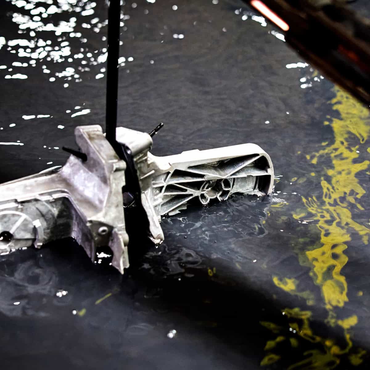 Car transmission submerged in water during repair process.