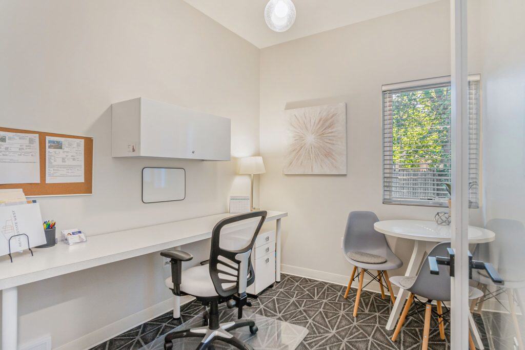 Modern home office space with desk, computer, and seating, ideal for remote work in West Michigan real estate market.