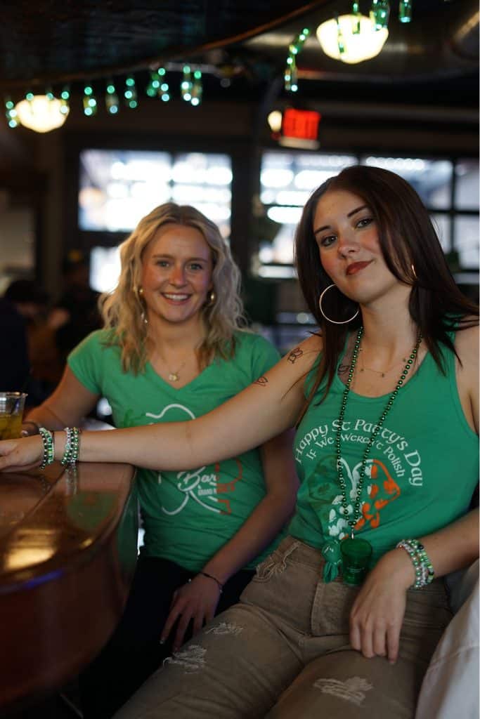 Shamrock on Stocking pub with two women celebrating St. Patrick's Day.