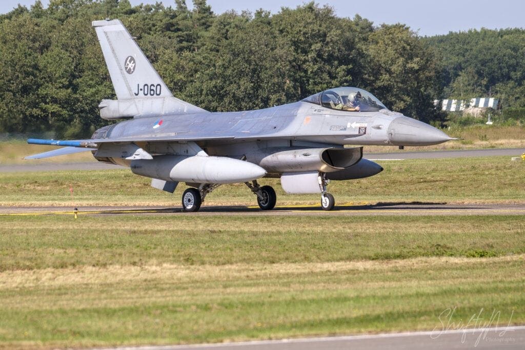F-16 Fighting Falcon jet aircraft taxiing on runway during airshow, showcasing military aviation skills and sleek design.