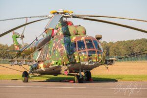 Nice Camouflage Military helicopter with camouflage pattern parked on runway, ready for deployment, under clear sky, showcasing advanced aviation technology and design.