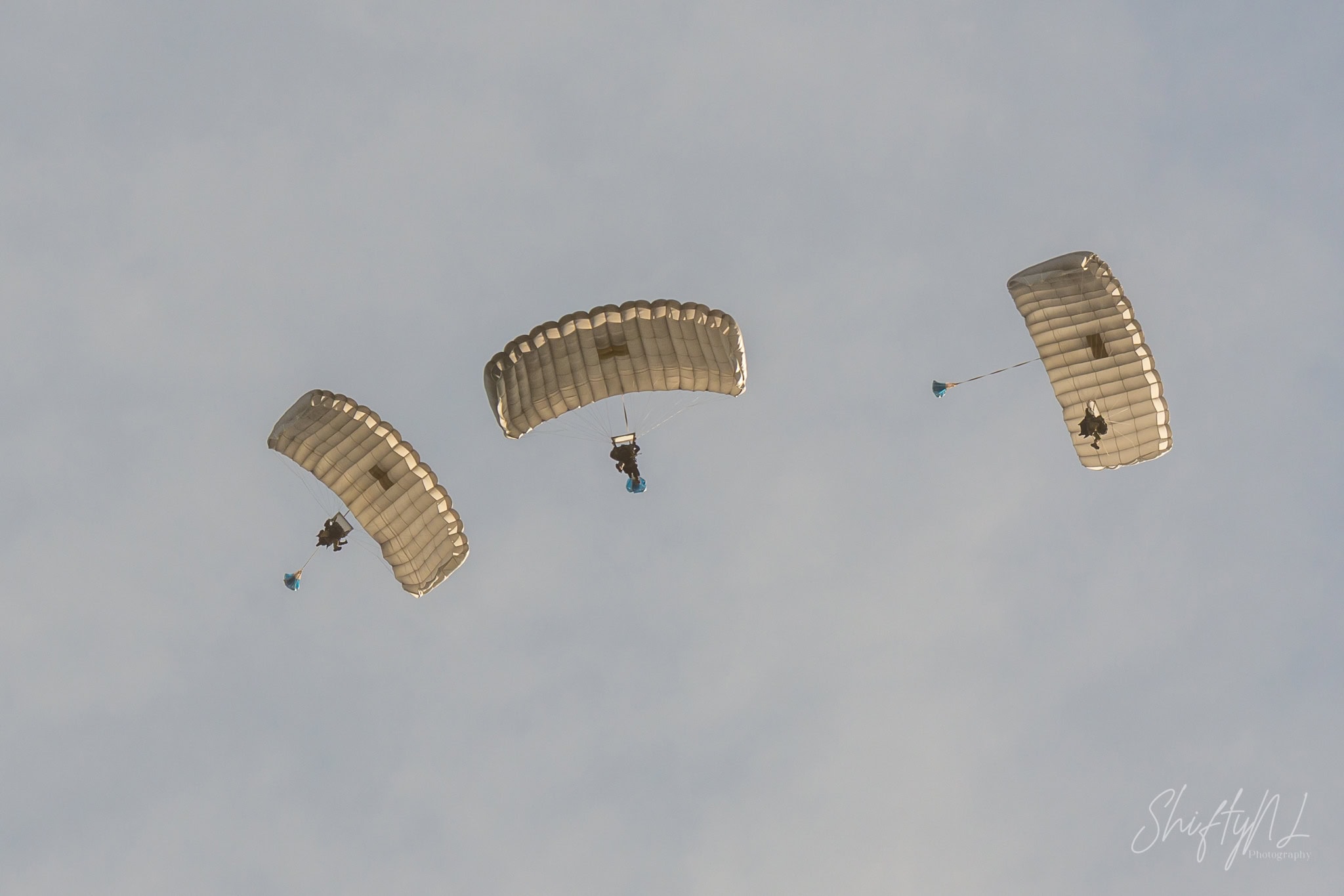 Three Pathfinder paratroopers under square canopies descending over Deelen Air Base, during exercise Falcon Autumn, the Netherlands, October 2018.