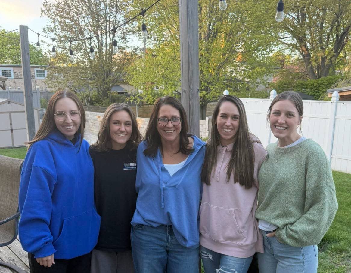 Group of smiling women at Smutz Girls Bakery outdoor event.