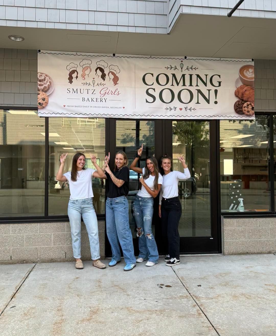 Four women celebrating in front of Smutz Girls Bakery storefront with a 'Coming Soon' banner.